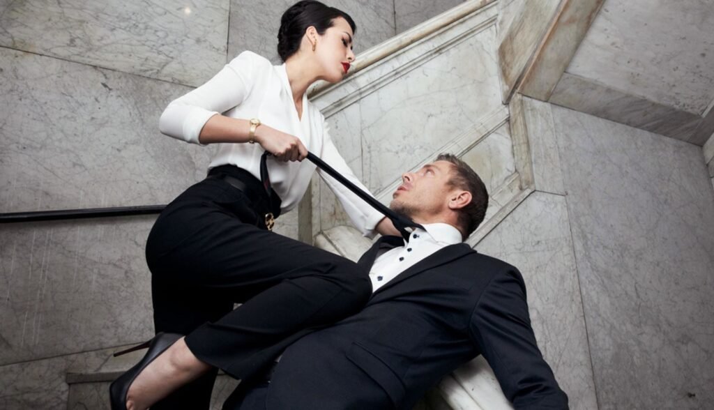 Mistress in elegant leather attire commanding obedience