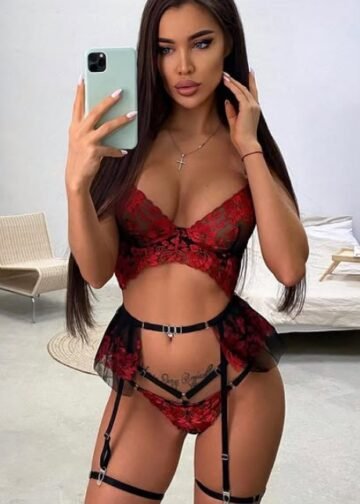 Katalyna capturing a seductive selfie in striking red lingerie with black straps and a confident pose in a modern room