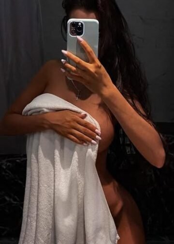 Katalyna taking a mirror selfie holding a towel over her body offering a discreet and intimate glimpse into her sensual world