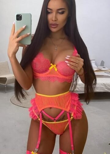 Katalyna posing in vibrant pink and yellow lace lingerie capturing a teasing mirror selfie with a seductive expression